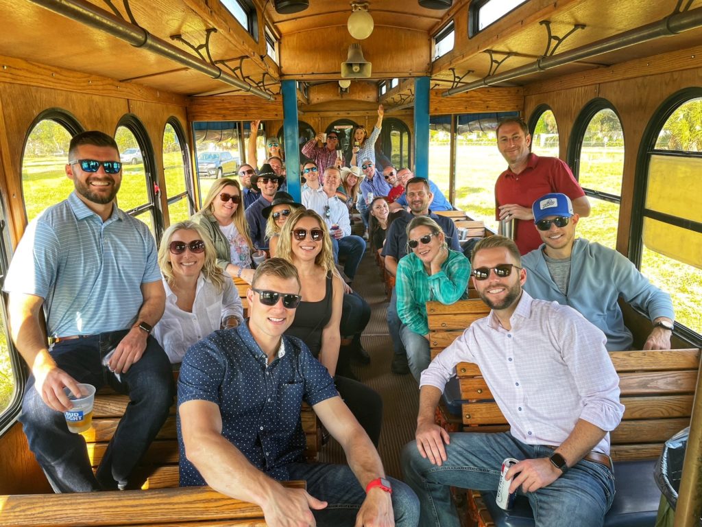 Large group on a trolley going to Farm City BBQ, Barron Collier Companies employees