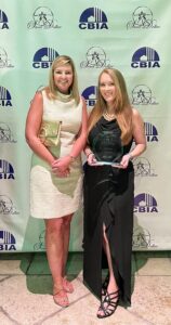Two ladies standing with award for Ave Maria Florida