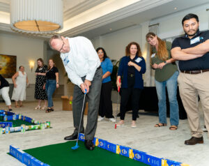 BCC employee takes a golf swing.